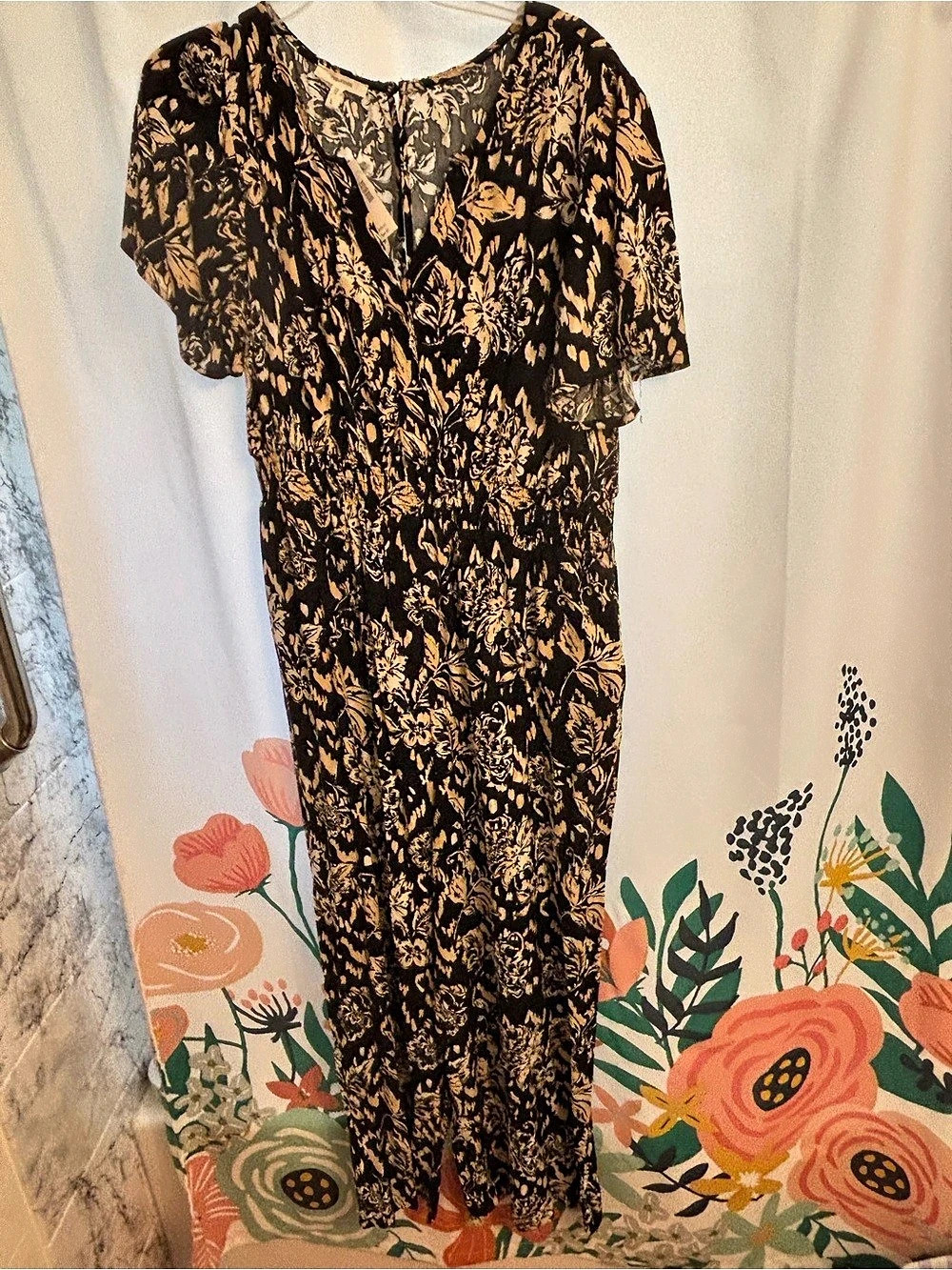 Maurices Floral jumpsuit in Black, Cream and Tan. Flutter sleeves, smocked waist